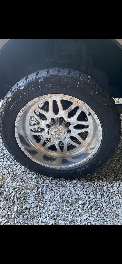 Clean, wet, and shiny custom wheel with all-terrain tire showing professional wheel and tire detailing results